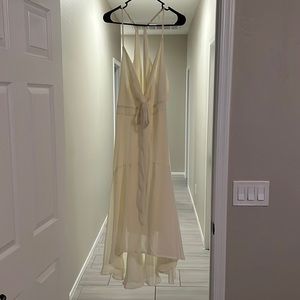 Yellow semi formal dress. Cutout in the back and the front. V-neck with tie.